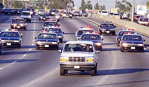 California Highway Patrol chase Al Cowlings (driving) and O.J. Simpson, hiding in rear of the white Bronco, on June 17, 1994 in Los Angeles.