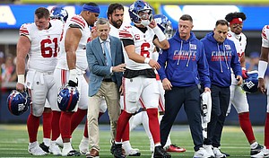 Jaxson Dart walks off the field after a play against the Los Angeles Rams during the first quarter of the game at SoFi Stadium.