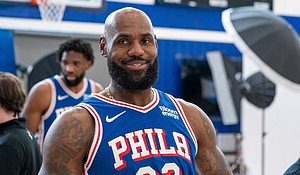 Philadelphia 76ers' LeBron James reacts as he goes between stations during the NBA basketball team's media day in Camden, New Jersey.