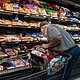 A shopper searches for meat products at a supermarket