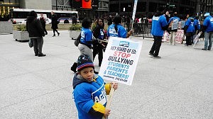 Lourdes Moore, 3,  holds a sign during a Chicago Teacher's Union rally and march last Wednesday afternoon at Daley Plaza where throngs gathered to protest proposed closures of 54 Chicago public schools. Phioto/ Deborah Bayliss