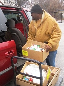 Thornton Township Pantry volunteer, Darryl Payne, loads a vehicle with food boxes.  Located in Harvey, IL the Thornton Township Pantry is one of 650 Chicago-area agencies that partners with the Greater Chicago Food Depository. (Citizen file photo)