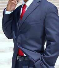 Suits are tailored, and colors are dark and sober, with luxury expressed mostly through the materials.