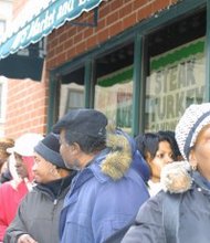 The line for a free meal wrapped around BJ's Market and Bakery Dec. 13 as St. Sabina church sponsored its second annual Operation Hope. Rev. Michael Pfleger, pastor of St. Sabina, said the event is as much about feeding the hungry as it is about letting poor people know that they are not forgotten. The community outreach event is a collaborative effort by St. Sabina, BJ's Market, Johnson Publishing Company, WVON-AM/1690, Rush University Medical Center and Terry Peterson. (Photo Credit: Rhonda Gillespie)