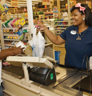 Elexus White, 17, rings up Food Lion customer Marvin Thompson last week in Charlotte. White is working three jobs to pay tuition at Ohio State University. Black teen unemployment in the U.S. is 31.8 percent.  PHOTO/CALVIN FERGUSON